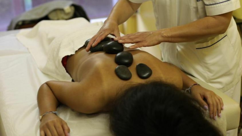 Mulher a receber uma massagem de pedras quentes nas Termas da Cúria