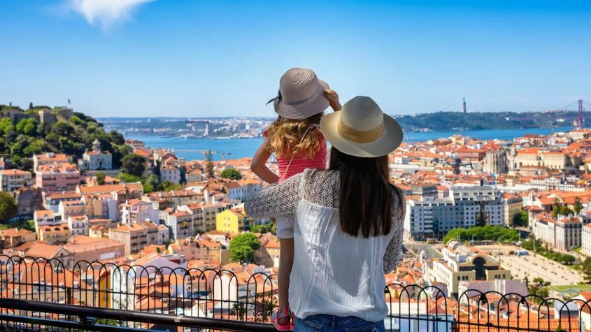 Turista e criança a contemplarem paisagem em Lisboa